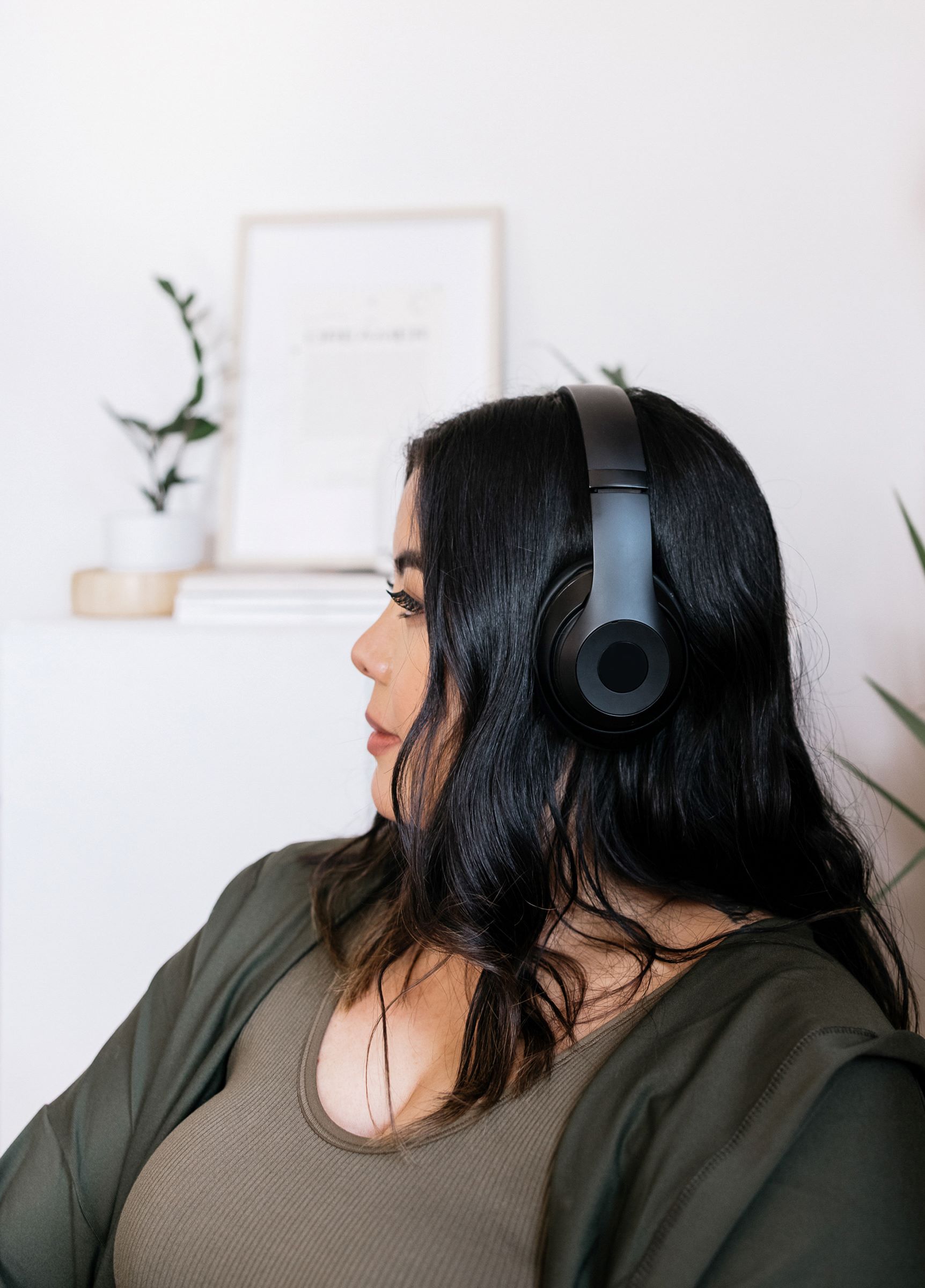 A woman wears headphones to review music while working